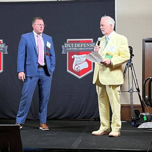 two lawyers holding awards